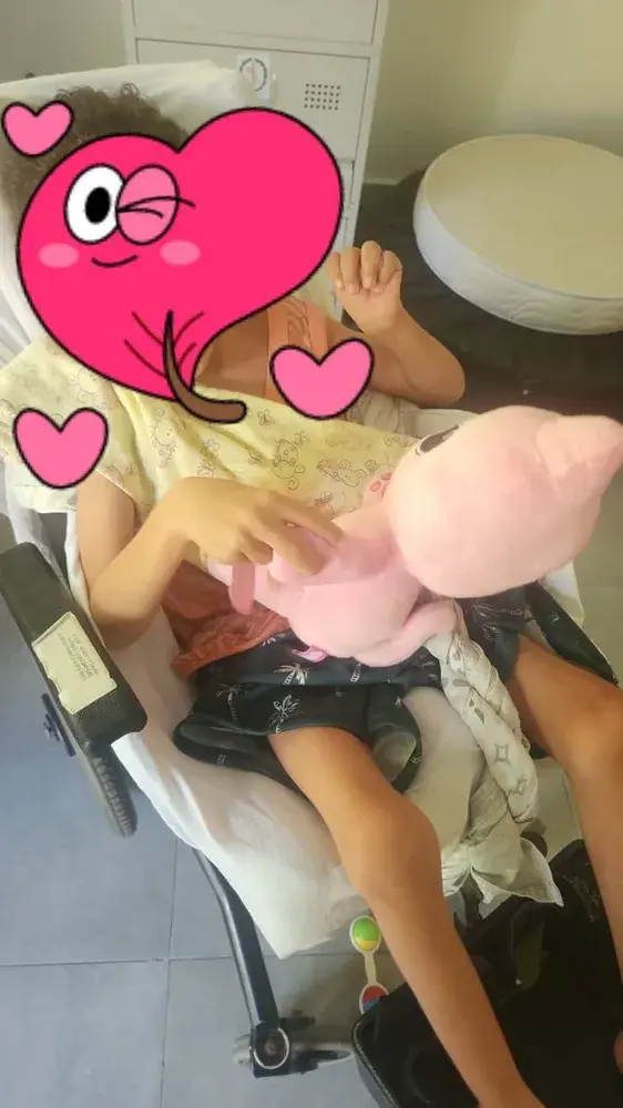 A child at the centre with one of the plush cats