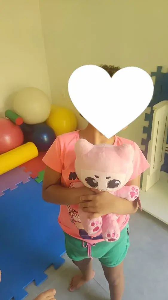 A child at the centre with one of the plush cats